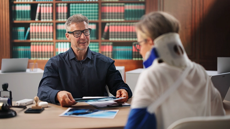 Personal injury lawyer reviews car accident claim with female client.